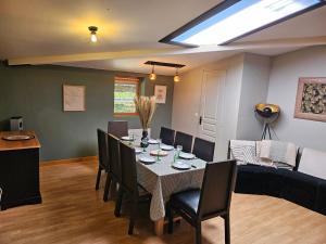 a dining room with a table and chairs and a couch at appartement Plume de repos in Marboué