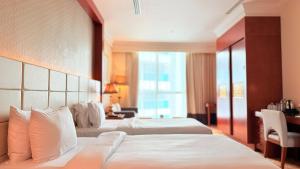 a hotel room with two beds and a large window at Sunday Hotel Al Barsha Dubai Mall of the Emirates Formerly Grand Excelsior Al barsha in Dubai