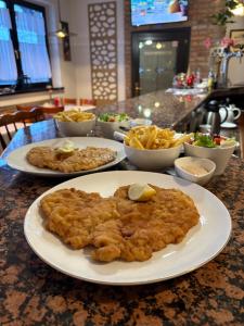 a table with two plates of food and french fries at A&P Motel in Mikołów +51 photos