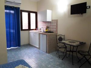 a kitchen with a sink and a table with chairs at Villa Lucia in Lampedusa