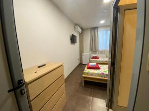a small room with a bed and a wooden door at Lifto Hostel in Voyvodinovo