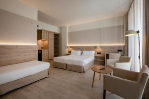 a hotel room with two beds and a table at Hotel Marina in Roses