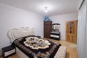 a bedroom with a bed with a black and white blanket at İvanovka Eco Home in İvanovka