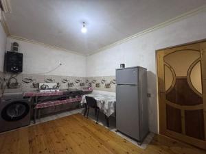 a kitchen with a table and a refrigerator in a room at İvanovka Eco Home in İvanovka
