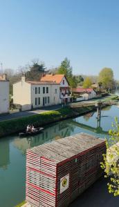 a small boat in a river with a house at Maison bord de sèvre in Coulon