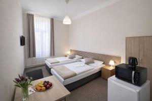a hotel room with two beds and a table at Hotel Hůrka in Pardubice