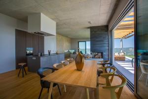 Una cocina y un comedor con mesa y sillas de madera. en Villa Vista Zamask, en Zamask
