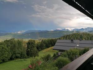 a view of a house with mountains in the background at Landhaus beim Pyramidenkogel in Linden