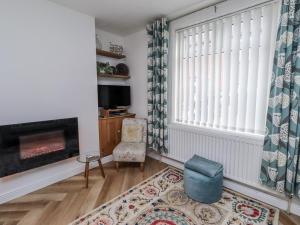 a living room with a fireplace and a window at Sea Mist in Newbiggin-by-the-Sea