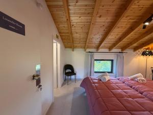a bedroom with a large bed with a red blanket at Cyherbia Botanical Park & Labyrinth in Avgorou