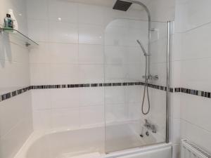a white bathroom with a shower and a tub at Sea Mist in Newbiggin-by-the-Sea +29 photos
