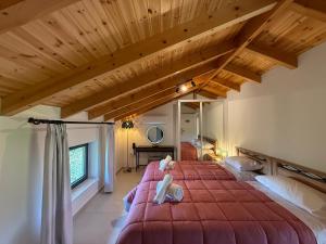 a bedroom with a large bed with two stuffed animals on it at Cyherbia Botanical Park & Labyrinth in Avgorou