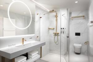 a white bathroom with a sink and a shower at Clarion Congress Hotel Brno in Brno