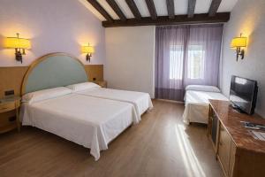 a hotel room with two beds and a flat screen tv at Gran Hotel Los Angeles in Getafe