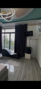 a living room with a bed and a television at Queen hotel in Cù Lao Nai