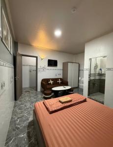 a bedroom with a bed and a couch and a television at Queen hotel in Cù Lao Nai