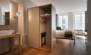 a room with a bedroom with a bed and a mirror at Baseltor Hotel & Restaurant in Solothurn