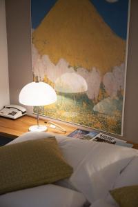 a bedroom with a bed with a painting on the wall at Baseltor Hotel & Restaurant in Solothurn