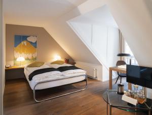 a bedroom with a bed and a desk and a tv at Baseltor Hotel & Restaurant in Solothurn +55 photos