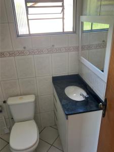 a bathroom with a toilet and a sink and a mirror at Panamá 90 - 21 - Região Central in Poços de Caldas