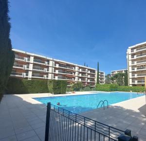 a swimming pool in front of a large apartment building at Appartement L'ECRIN DES EMPEREURS in Saint-Raphaël