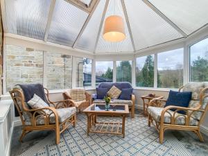 a conservatory with chairs and tables and windows at Denham in Glaisdale