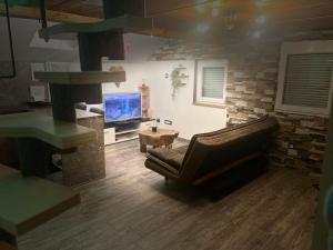 a living room with a couch and a television at Apartment Mastnak - Private Wellness & Jacuzzi in Laško