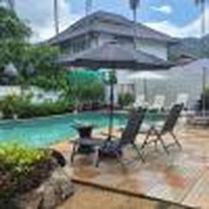 a patio with two chairs and an umbrella at Nur Nur Residence and villa in Surin Beach