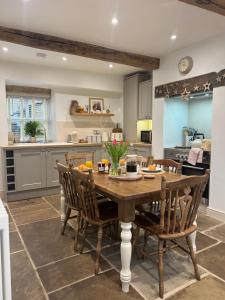 a kitchen with a wooden table and chairs at Bents Holiday Cottage, Views & Parking for two cars in Oxenhope
