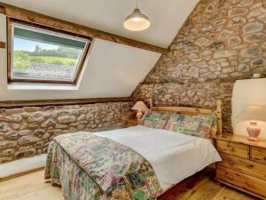 a bedroom with a stone wall at Horner- Ukc4923 in Timberscombe