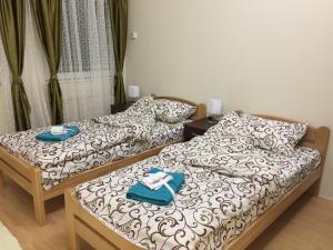 two beds in a room with towels on them at AMN Center Apartment in Belgrade