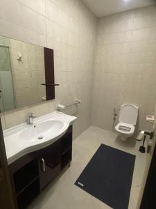 a bathroom with a sink and a toilet and a mirror at Maison 7 Residence in Obour +19 photos