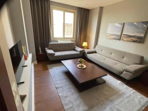 a living room with a couch and a coffee table at Maison 7 Residence in Obour