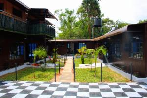 a courtyard with a checkered floor in front of buildings at Maya Stays in Busia
