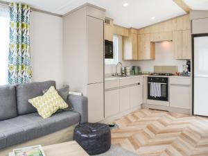 a living room with a couch and a kitchen at Baywood View in East Heslerton
