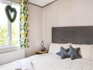 a bedroom with a bed with two pillows on it at Baywood View in East Heslerton +6 photos