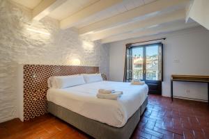 a bedroom with a large bed with towels on it at Flateli Santa Clara 22 in Girona