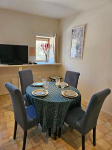 a dining room with a table with chairs and a television at appartement Plume de repos in Marboué