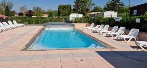 a pool with chaise lounge chairs and a swimming pool at Le Pont Rouge & Les Vignes in Chipilly