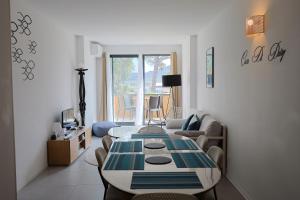 a living room with a table and a couch at Casa di Daisy - T2 les pieds dans l'eau et piscine in Pianottoli-Caldarello