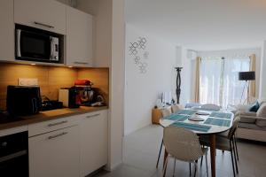 a kitchen and living room with a table and chairs at Casa di Daisy - T2 les pieds dans l'eau et piscine in Pianottoli-Caldarello