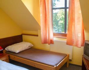 a small bedroom with a bed and a window at Penzion Pecák in Hatín
