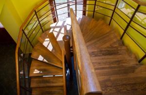 a wooden spiral staircase with a glass railing at Penzion Pecák in Hatín