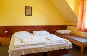 a bedroom with a bed and a bench in it at Penzion Pecák in Hatín