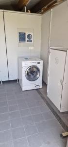 a laundry room with a washing machine and a refrigerator at Le Pont Rouge & Les Vignes in Chipilly