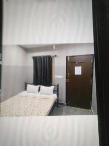 a small room with two beds and a door at Sri Krishnaa comforts in Bangalore