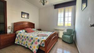 a bedroom with a bed and a chair at Fogar do Faustino,Rianxo by Cristian&Tamara "alquileres" in Rianjo