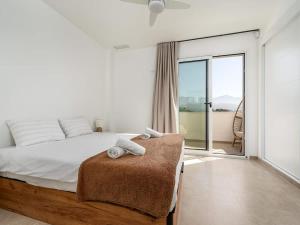 a white bedroom with a bed and a balcony at Luxury 2 Bedrooms Apartment Bayview Hills Nerja in Torrox