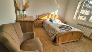 a bedroom with a bed with a chair and a dresser at Fogar do Faustino,Rianxo by Cristian&Tamara "alquileres" in Rianjo