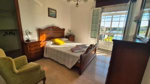 a bedroom with a bed and a chair and a window at Fogar do Faustino,Rianxo by Cristian&Tamara "alquileres" in Rianjo +49 photos